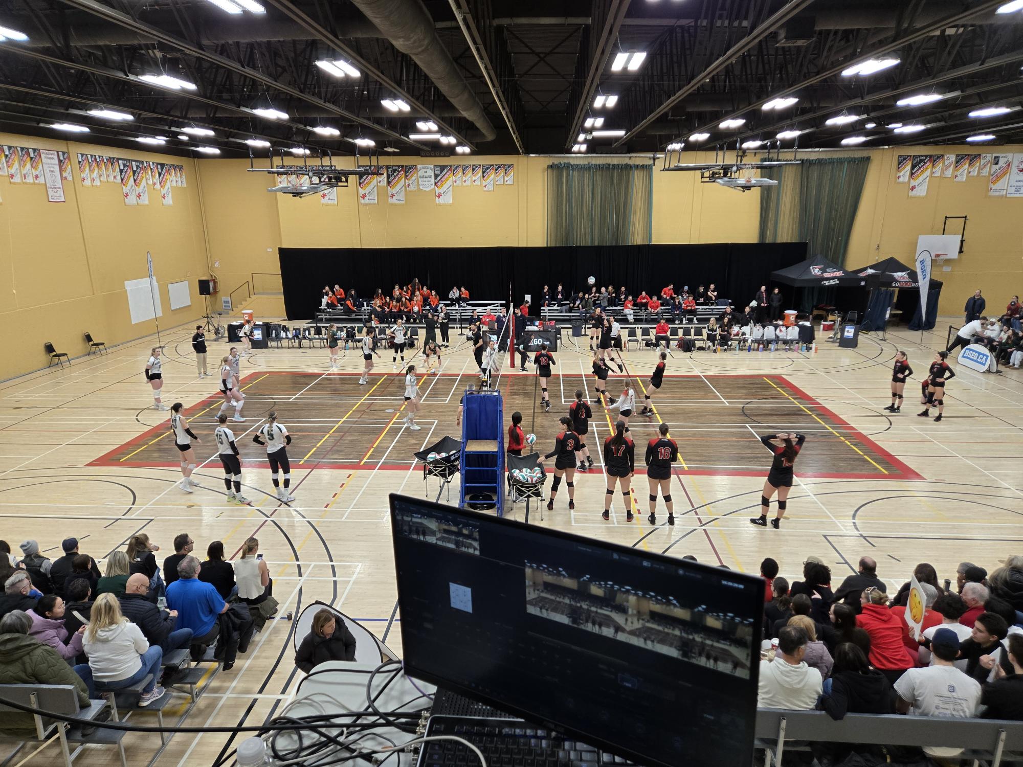 Tournoi_Volleyball_2025 Terrain de volleyball avec personnes spectatrices, joueurs et joueuses.